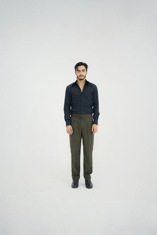 Man wearing a black shirt and green pants on a white background