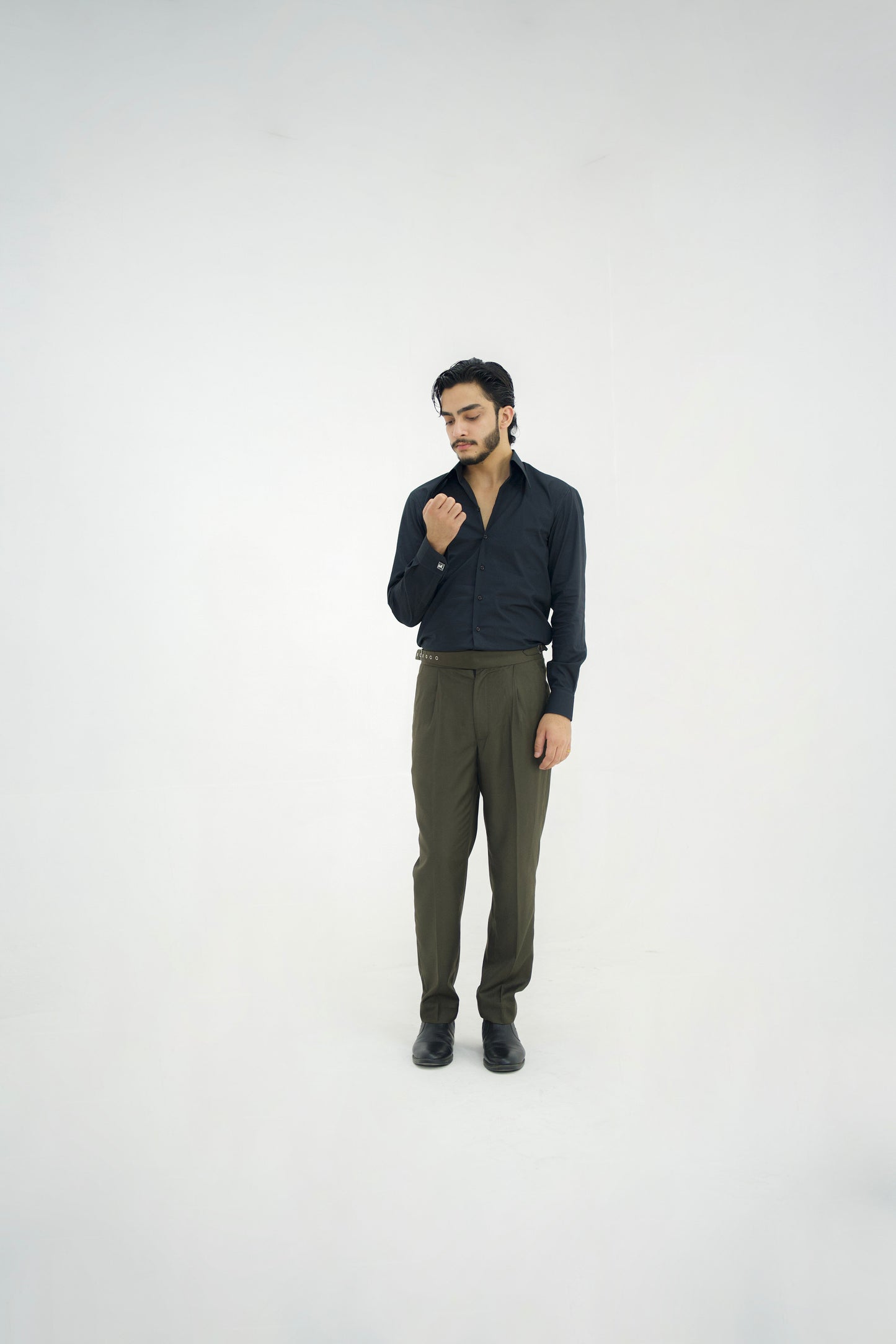 Man wearing a dark shirt and green pants on a white background