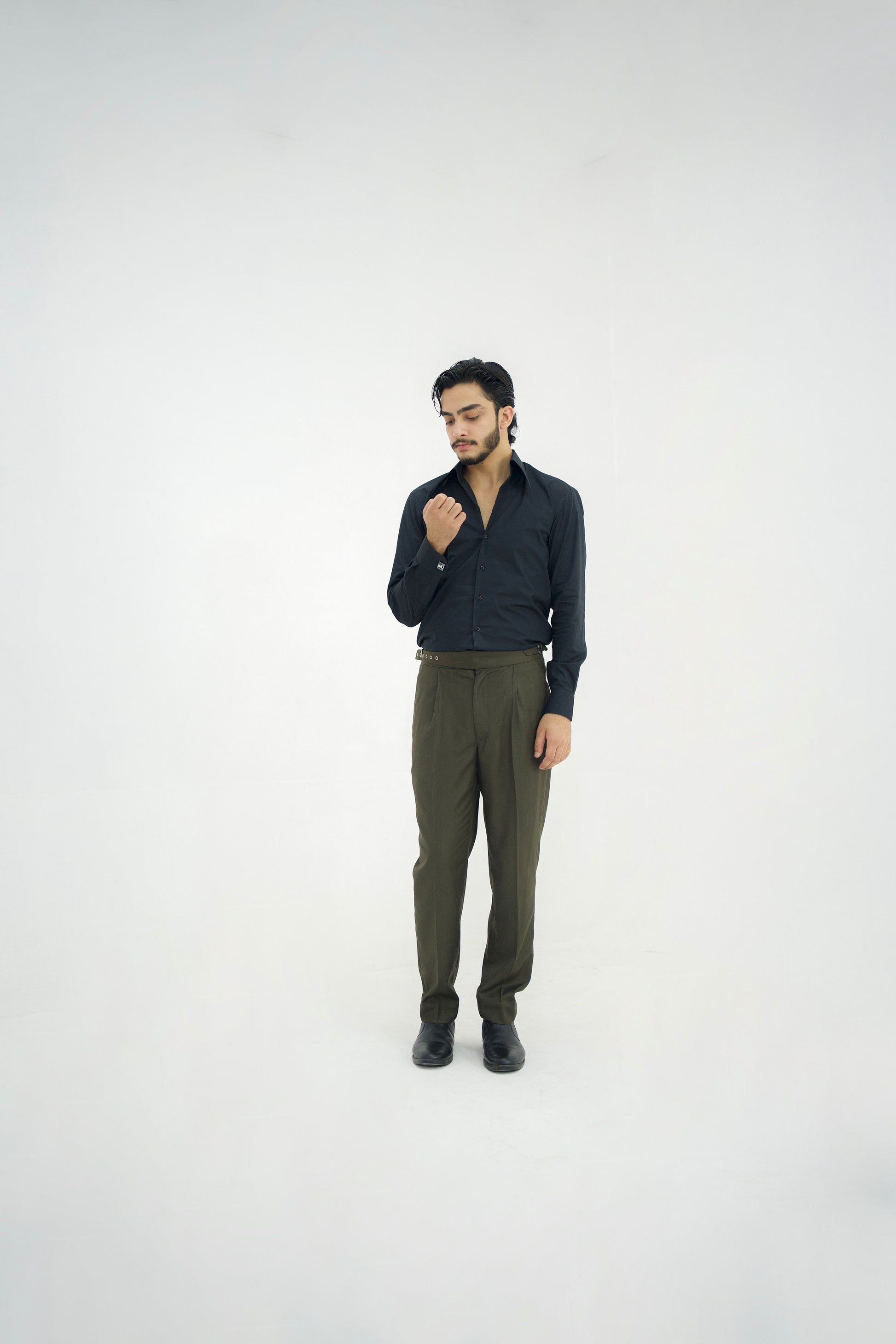 Man wearing a dark shirt and green pants on a white background