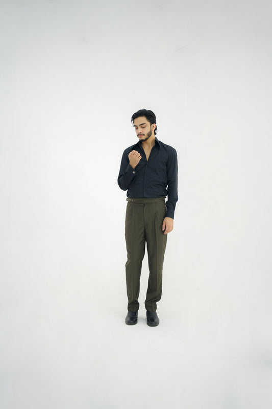Man wearing a dark shirt and green pants on a white background