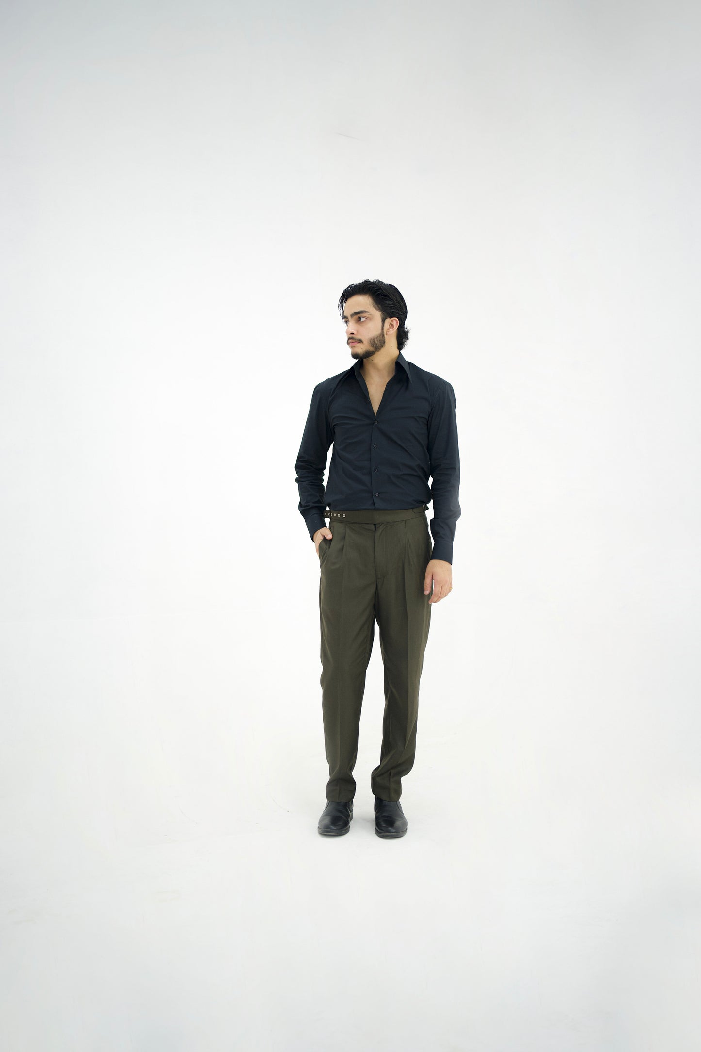 Man wearing a dark shirt and green pants on a white background