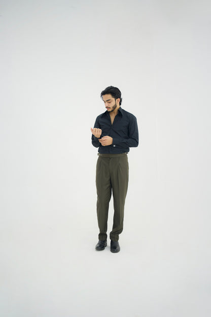 Man wearing a dark shirt and green pants on a white background